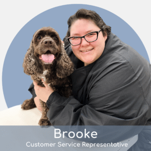 A smiling person wearing glasses and a dark jacket hugs a happy brown dog. The background is a light blue circle. Text at the bottom reads: "Brooke, Customer Service Representative.